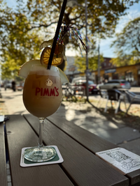 Leckerer Cocktail im Vordergrund, im Hintergrund die sonnige Karl-Liebknecht-Stra&szlig;e in Leipzig